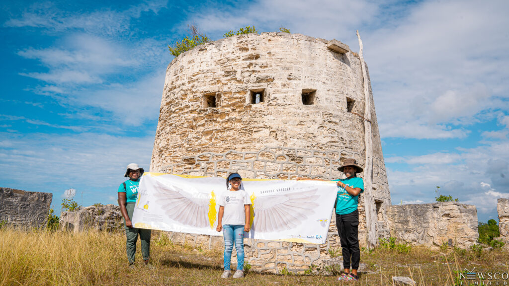 8 student poses with barbuda warbler wings at martello tower credits chaso media